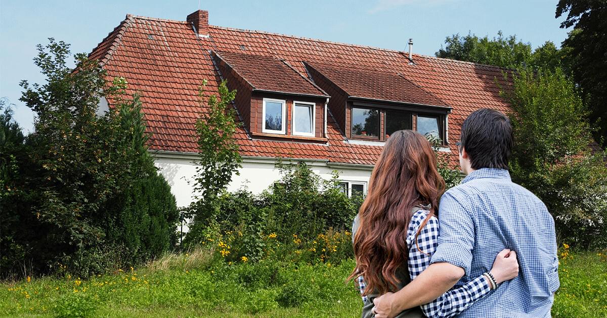 Due persone davanti a una casa 